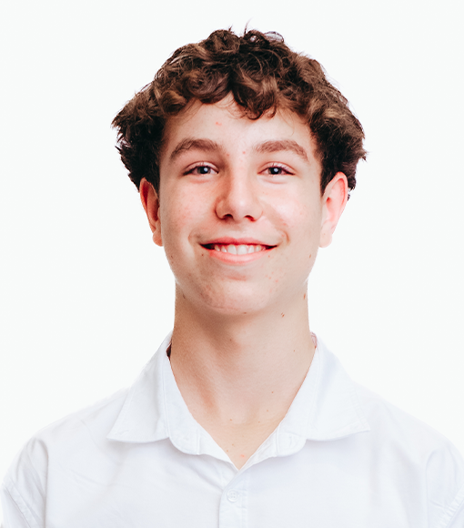 Caleb - headshot of a young man with short, brown, curly hair wearing a white collared shirt.