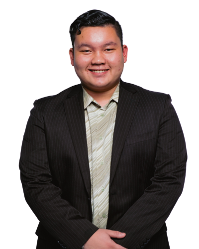 Image of Chris. A man with short dark hair, wearing a beige collared shirt and black blazer smiling.