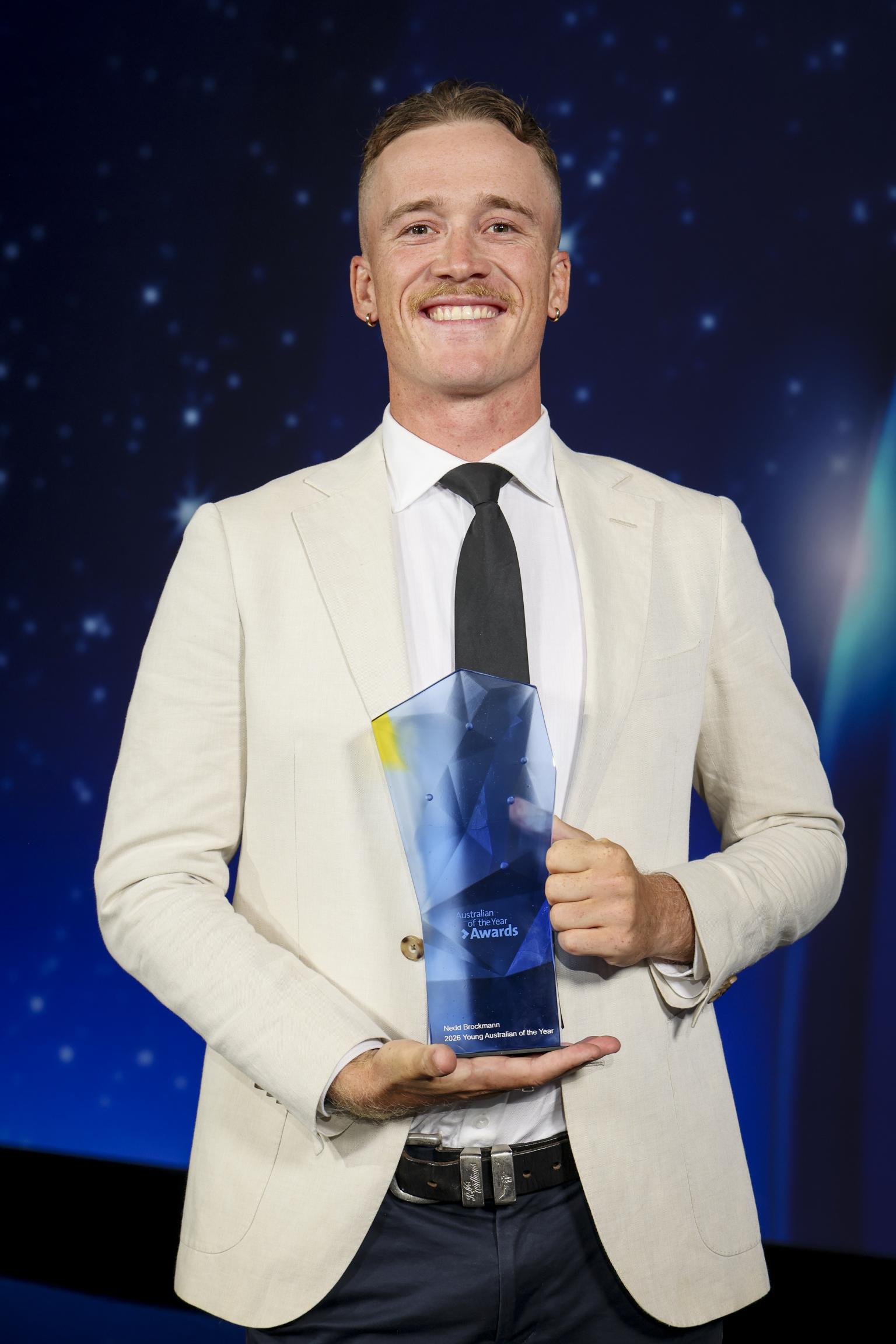 Nedd Brockmann holding an award