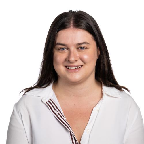 Image of Amy smiling at the camera with long straight hair wearing a collared shirt.