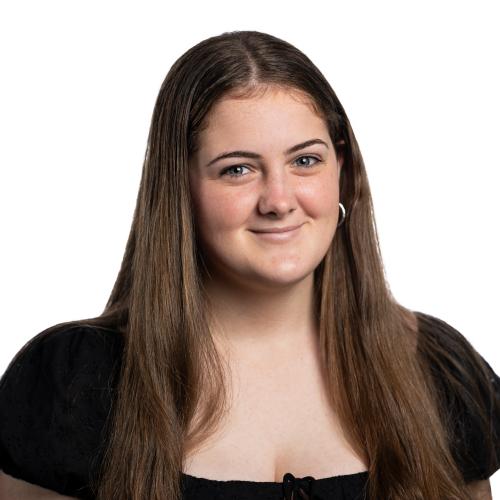 Image of Annika smiling with long straight hair wearing a blouse.