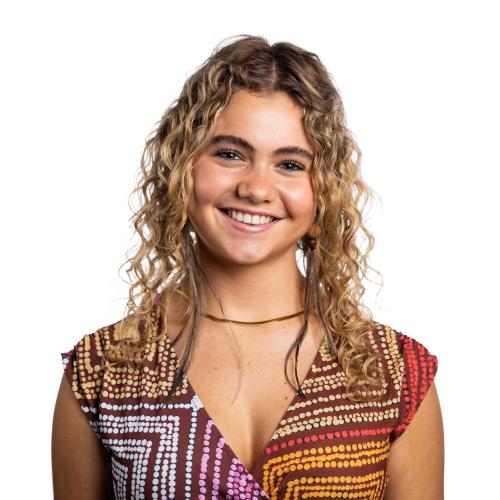 Image of Aurielle smiling at the camera with shoulder length, curly hair.