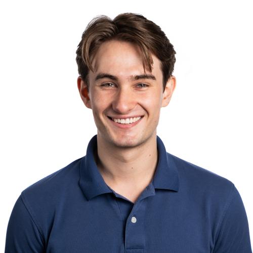 Headshot of Charlie smiling at the camera with short hair and a collared polo shirt.