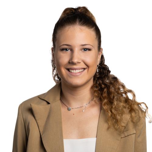 Image of Jessica smiling with long curly hair tied up, wearing a t-shirt and blazer.