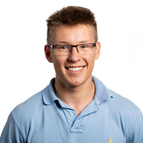 Image of Joshua smiling at the camera wearing spectacles.