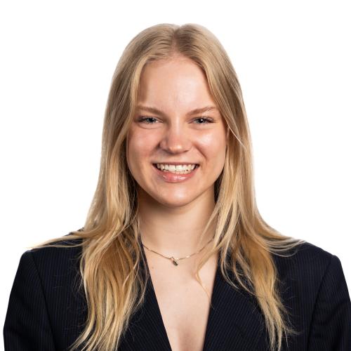 Image of Mia smiling with long straight hair and wearing a long sleeved top.