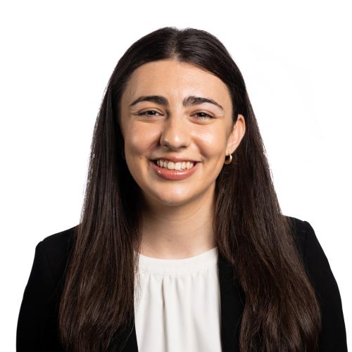 Headshot of Michaela looking at the camera smiling with long straight hair.