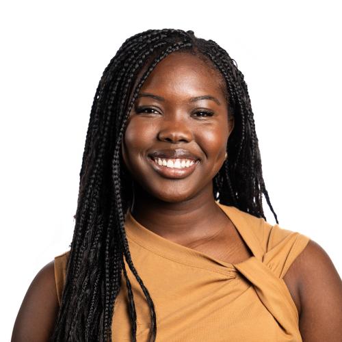 Headshot of Nyarath smiling at the camera with long braided hair.