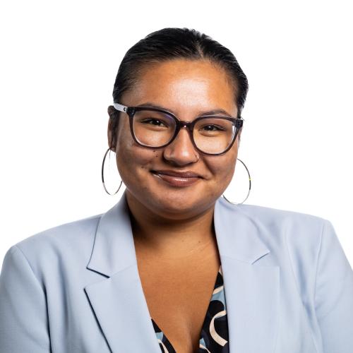 Image of Tequeah smiling wearing glasses, hoop earrings a blouse with a blazer.