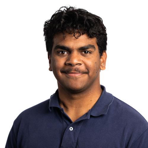 Image of Tremane smiling with short, curly hair, a moustache wearing a collared t-shirt.