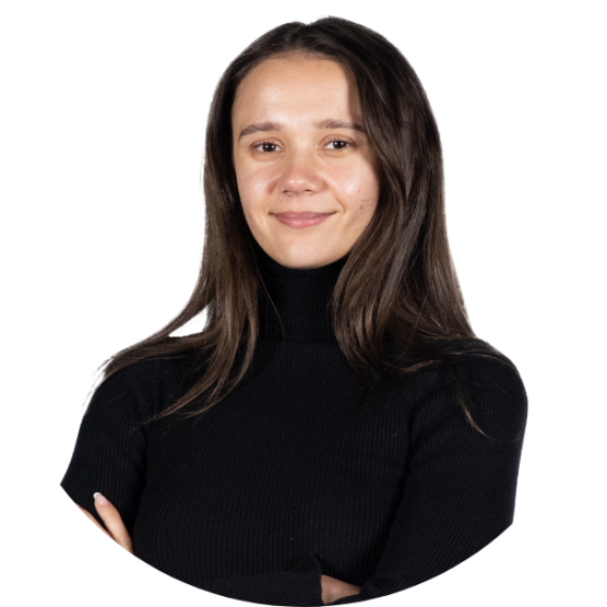 Young person with long dark hair wearing a long sleeved black shirt, smiling.