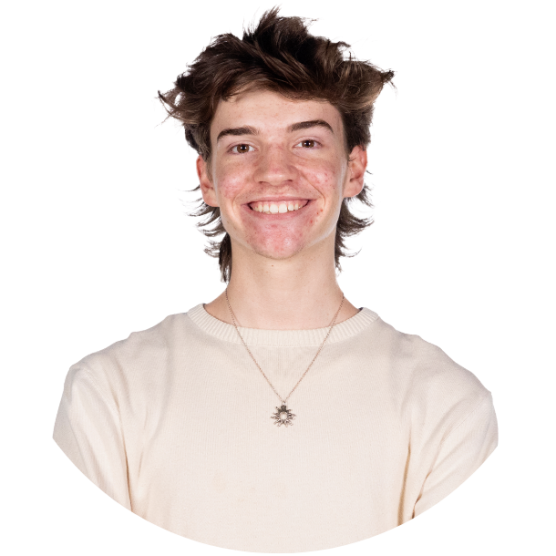 Young person wearing a long sleeved shirt, smiling.